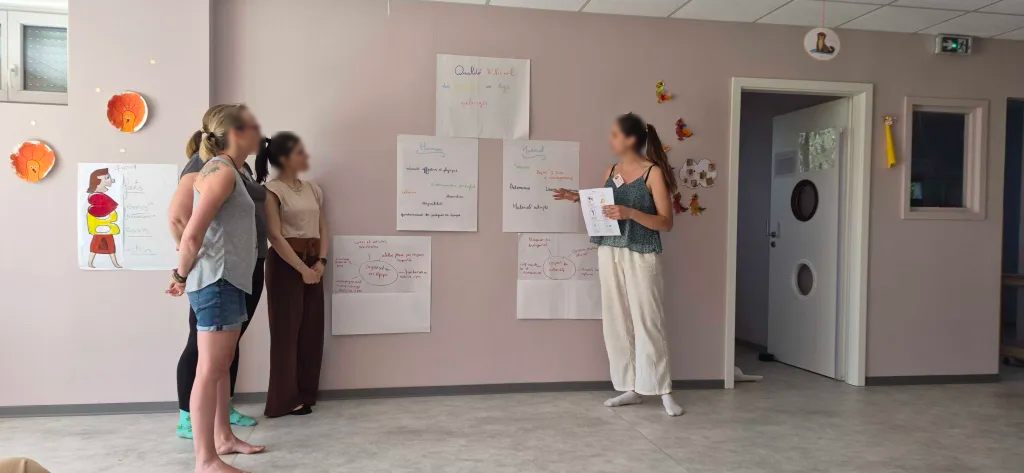 Séance de formation professionnelle en micro-crèche, autour d'affiches sur la qualité d'accueil